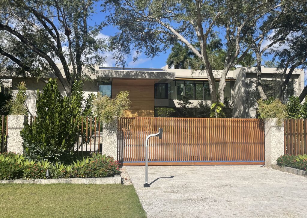 Street view of a gated South Florida home with impact windows and doors