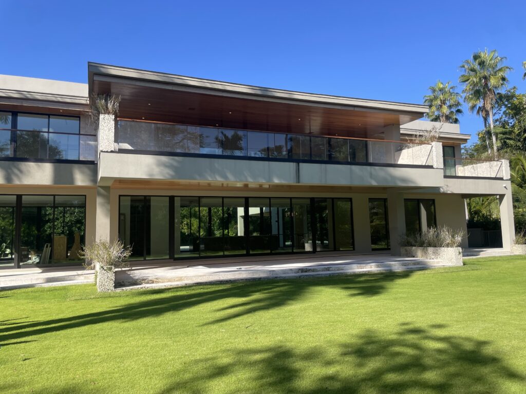 Backyard view shot of a luxury South Florida residential building with impact windows installed